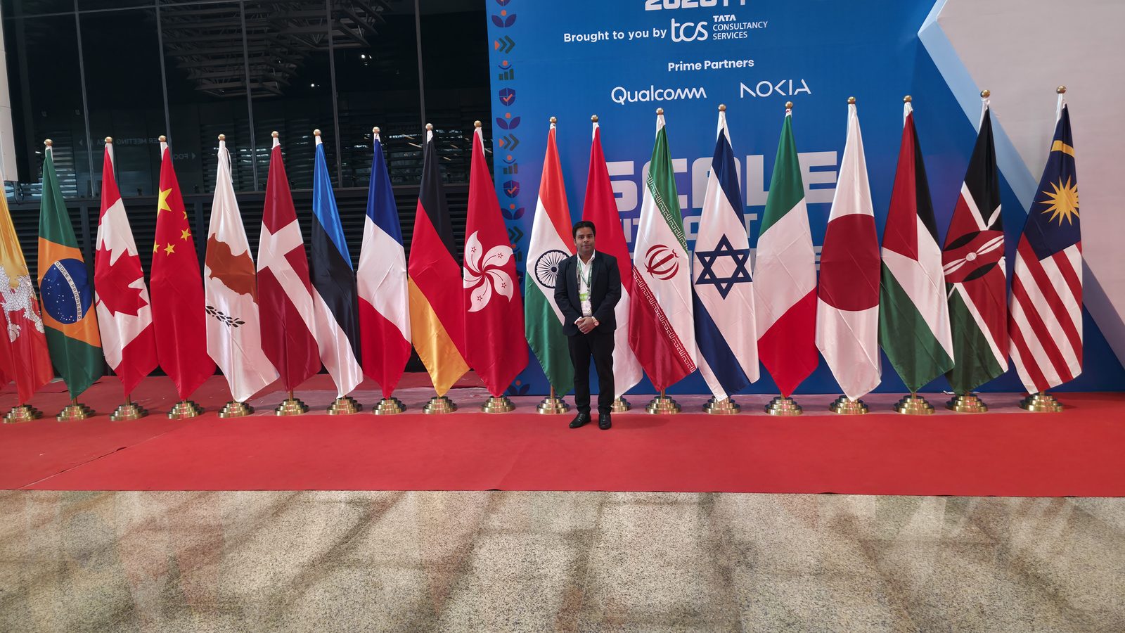 Kabad Hatao team member with the international flags at IMC 2026.