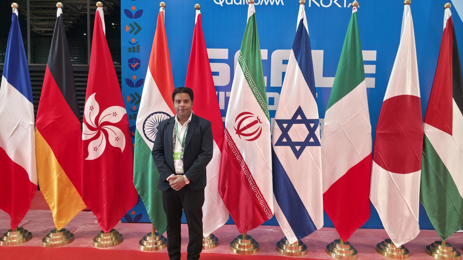 Team member in front of the country flags at IMC 2026.