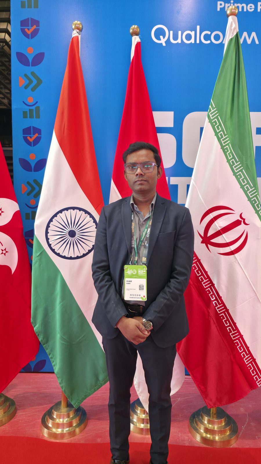 Team member beside the Indian flag at India Mobile Congress.