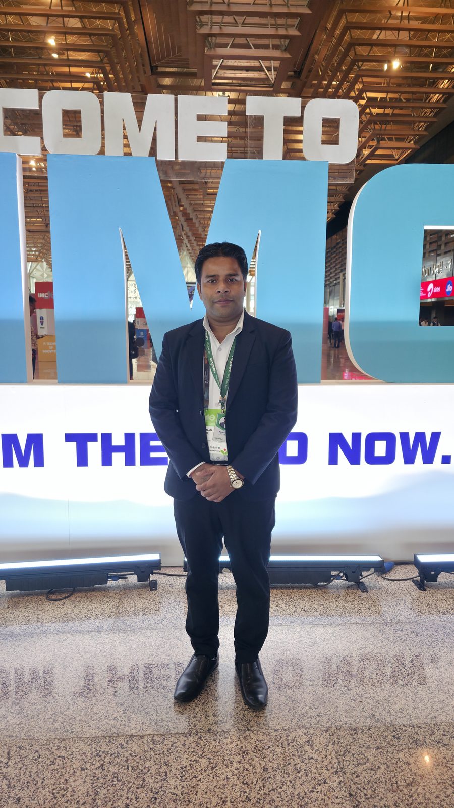 Team member in front of the IMC letters.