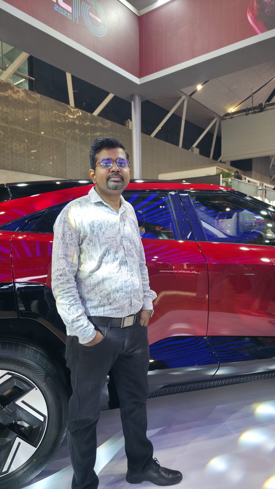 A teammate beside a display on the IMC show floor.