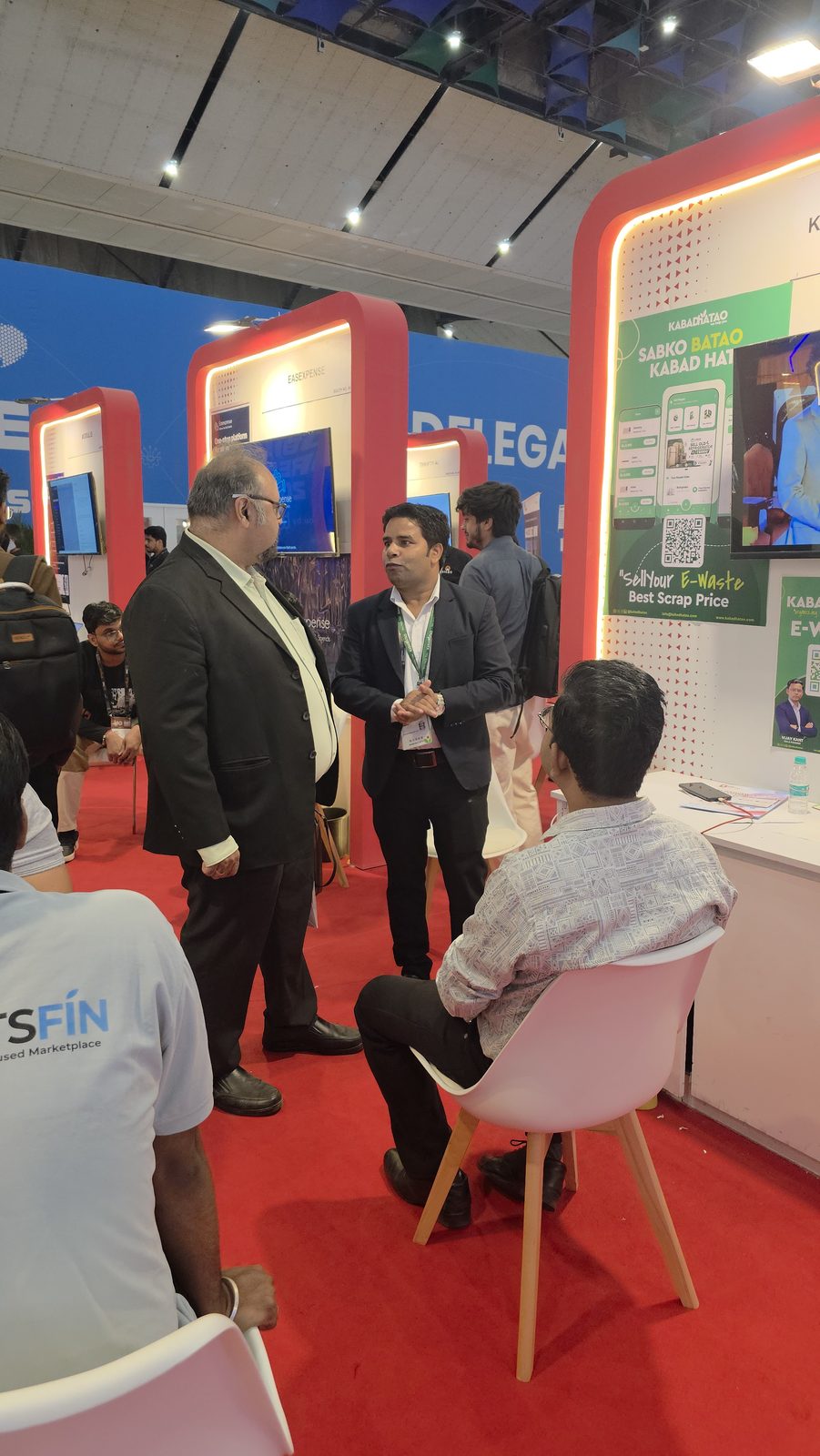 A client conversation beside booth AI-155.
