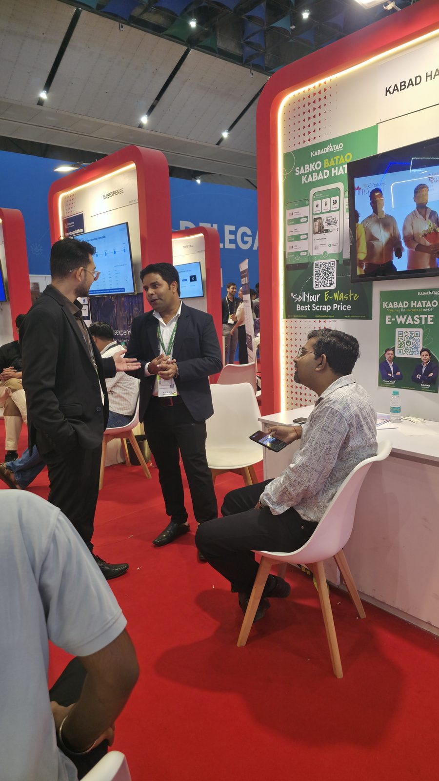 A client conversation beside booth AI-155.